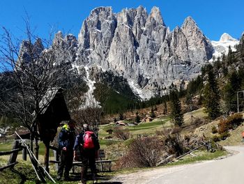 Rear view of people walking on mountain against sky