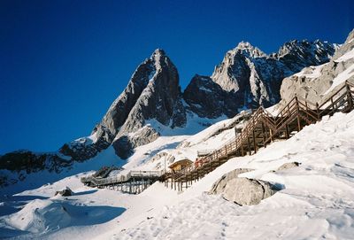 Scenic view of snowcapped mountains against clear blue sky