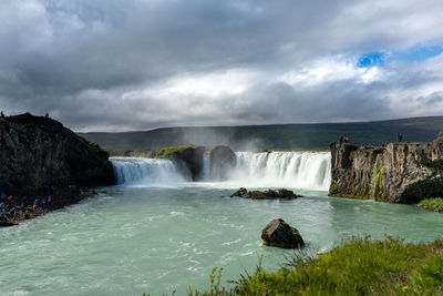 Scenic view of waterfall against sky