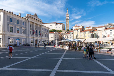 People on road amidst buildings in city