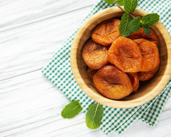 Dried apricots on white rustic wooden background