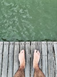 Low section of person walking on pier