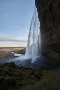 Scenic view of waterfall against sky during sunset