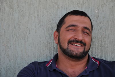 Portrait of smiling man against wall