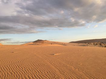 Sand dunes in desert against sky