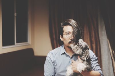 Portrait of young man holding dog