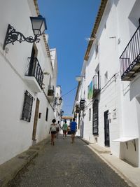 People walking on street amidst buildings in city