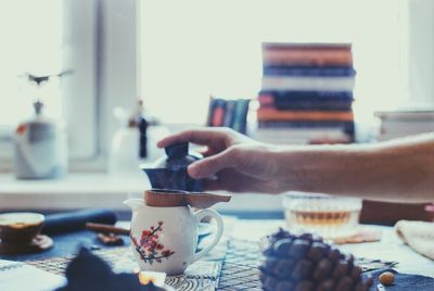 Close-up of hand holding teapot