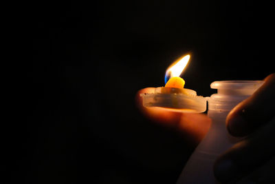 Close-up of burning candles in darkroom