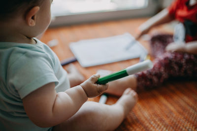 Midsection of boy holding table at home