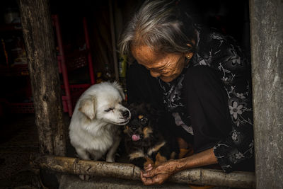 Senior woman with dogs sitting at entrance