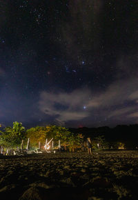 Scenic view of illuminated field against sky at night