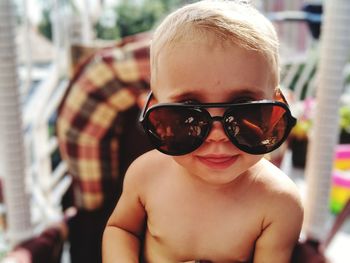 Portrait of shirtless baby girl wearing sunglasses