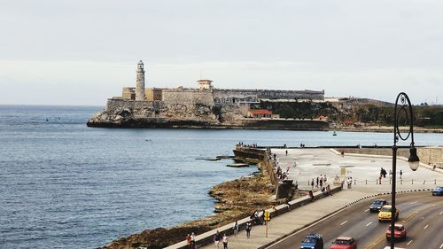 View of lighthouse by sea against sky