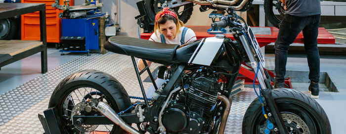 Mechanic checking custom motorcycle on garage