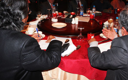 Midsection of people at dining table