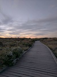 View of boardwalk against sky during sunset