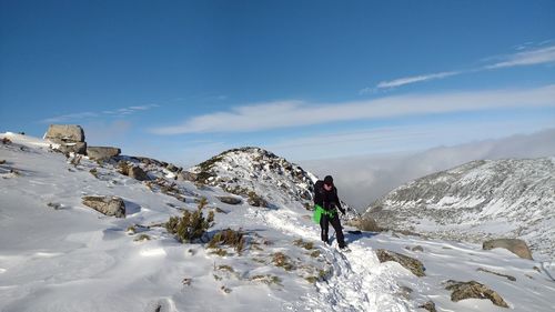 Women hiking on snowcapped mountain against sky