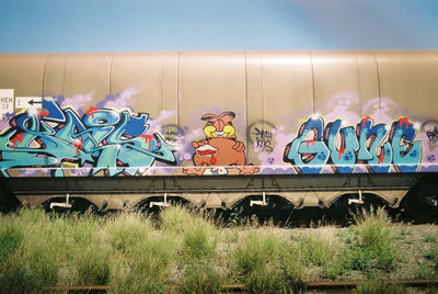 Graffiti on train against sky
