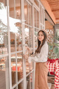 Portrait of a smiling young woman standing in store
