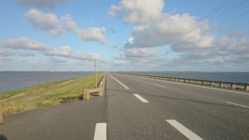 Empty road against cloudy sky