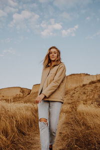 Portrait of woman walking on land against sky