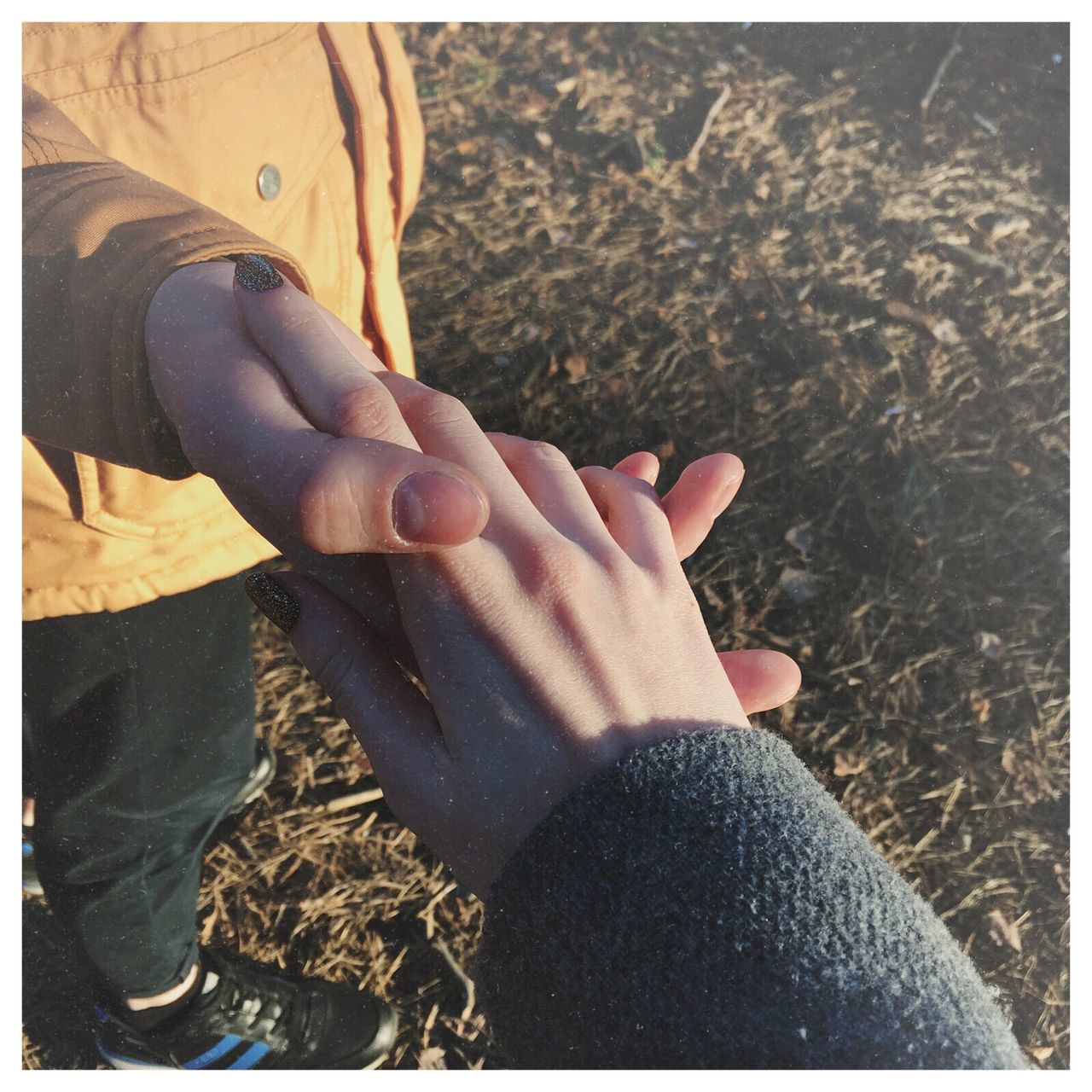 CLOSE-UP OF HAND HOLDING HANDS AGAINST BLURRED BACKGROUND