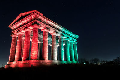 Low angle view of illuminated building against sky at night