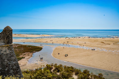 Scenic view of beach against blue sky