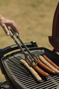 Close-up of hand on barbecue grill