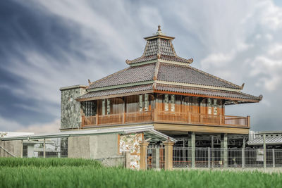 Exterior of building on field against sky