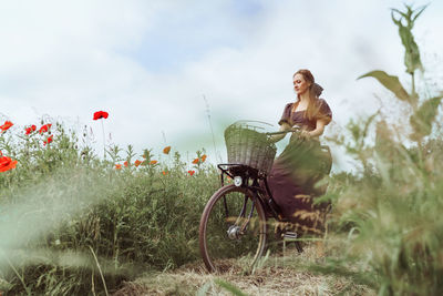 Rear view of woman riding bicycle on field