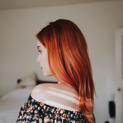 Side view of woman with redhead at home