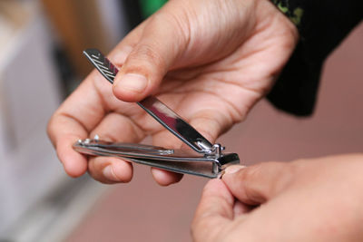 Cropped hands cutting nail