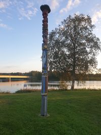 Built structure on field by lake against sky