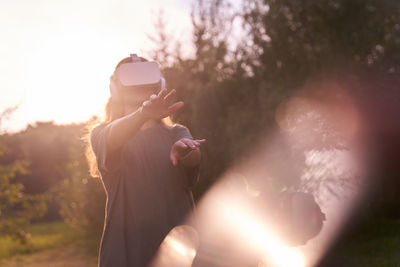 Side view of woman holding sparkler against sky