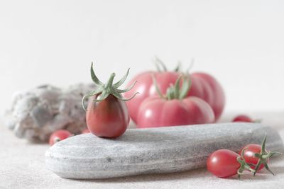 Close-up of cherry tomatoes on table against white background