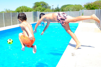 Boy jumping in swimming pool