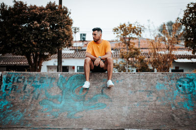 Portrait of young man standing against fountain