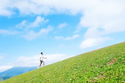 Man with bicycle on field against sky