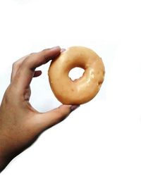 Close-up of hand holding food over white background