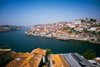 High angle view of townscape by sea against clear sky