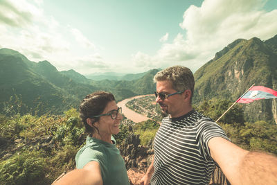 Low section of friends on mountain against sky