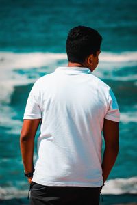 Rear view of man standing in sea