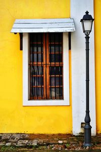 Street light against yellow building