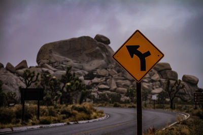 Road sign against sky