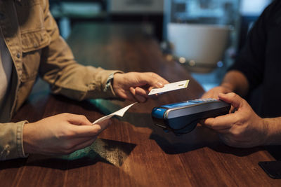 Man's hands paying with credit card in restaurant