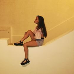 Young woman sitting on wall