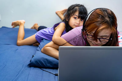 Mother using laptop with daughter at home