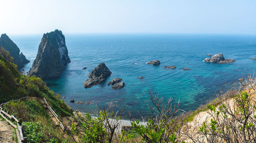 High angle view of rocks in sea against clear sky